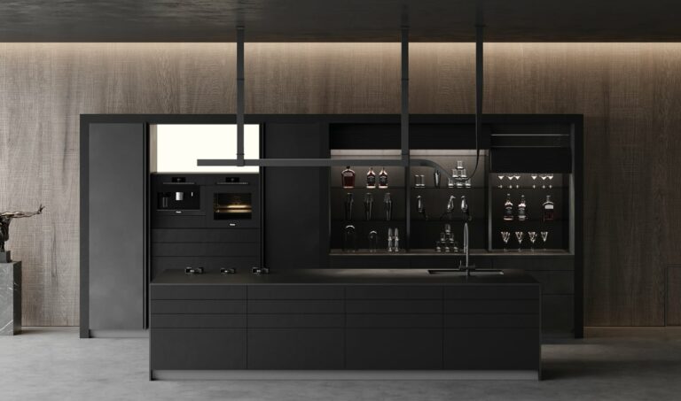 A modern, ergonomic kitchen showcases a sleek black island and dark cabinetry. The back wall features built-in appliances, shelves with glassware, and a wine collection under ambient lighting.