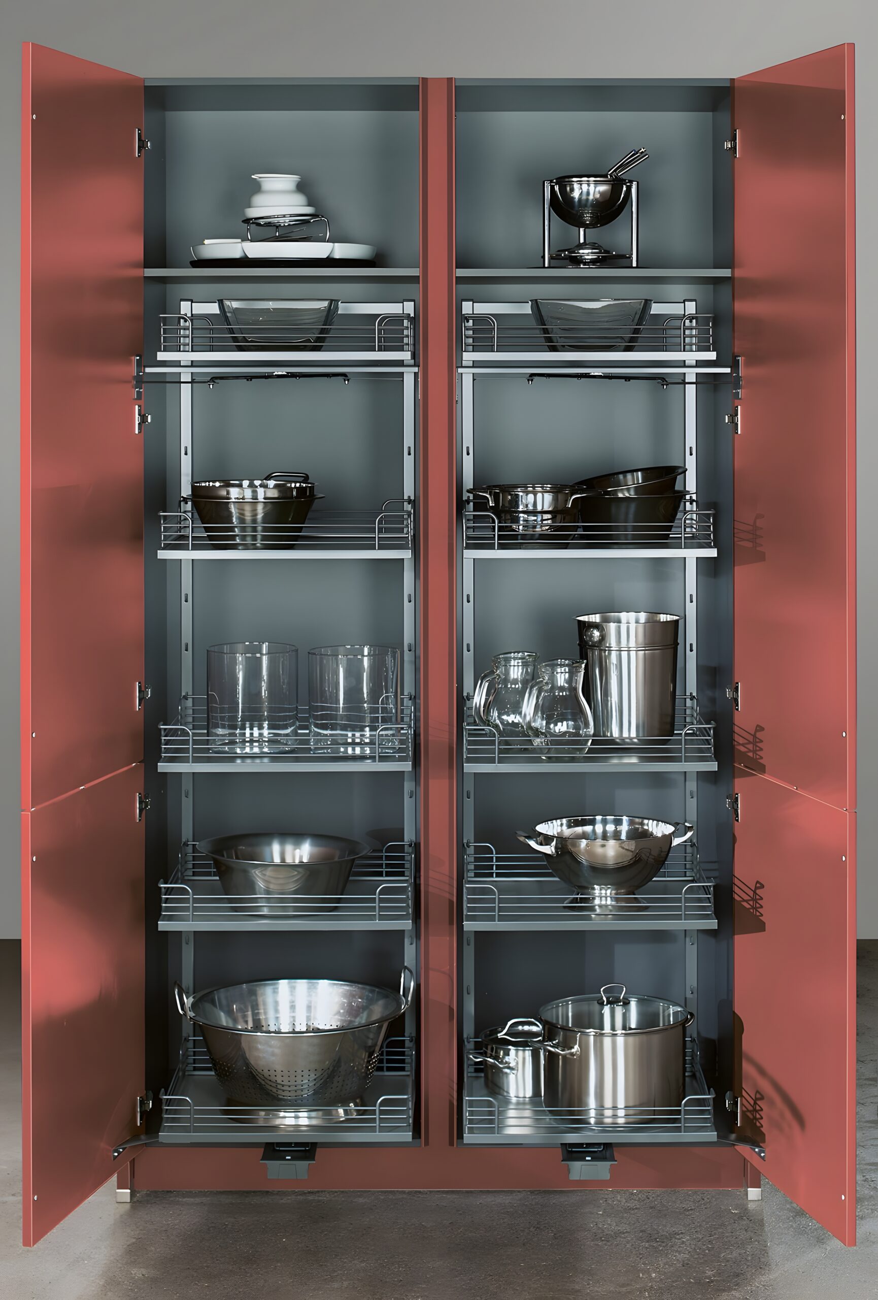 A neatly organized kitchen cabinet with open doors displaying a collection of pots, pans, and glassware on shelves, showcasing creative use of space for small pantries.