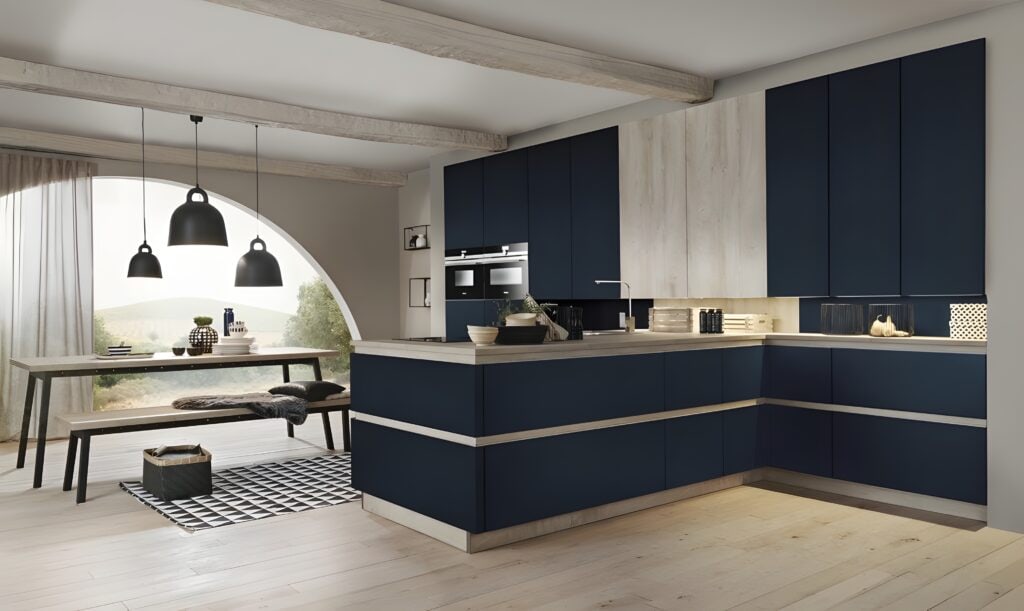 Modern kitchen with dark blue cabinets, light wood accents, and built-in appliances. An ergonomic kitchen layout ensures ease of use. A wooden dining table with benches is in the background, near a large arched window.