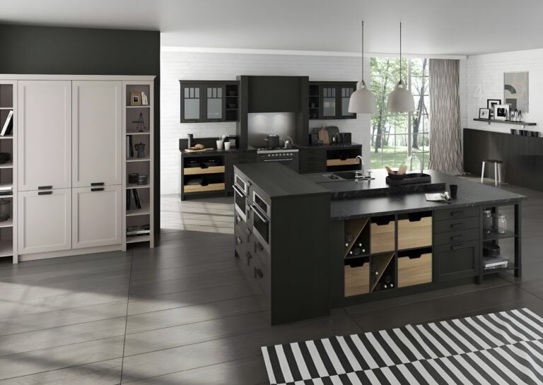 Modern black kitchen with German cabinetry, a large island featuring built-in appliances and storage, pendant lights, and an adjacent dining area. Highlights include a striped rug and floor-to-ceiling windows.