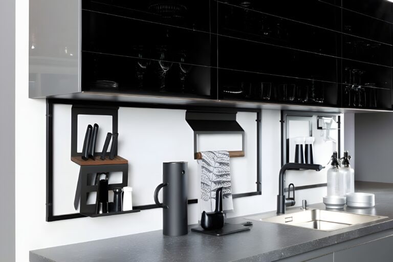 A modern kitchen with a grey countertop, black fixtures, knife holder, utensils, and a tall cylinder container. The sink has a black faucet, and the wall features shelves with multiple kitchen items. Integrating the internet of things in kitchen design adds smart functionality to this sleek space.