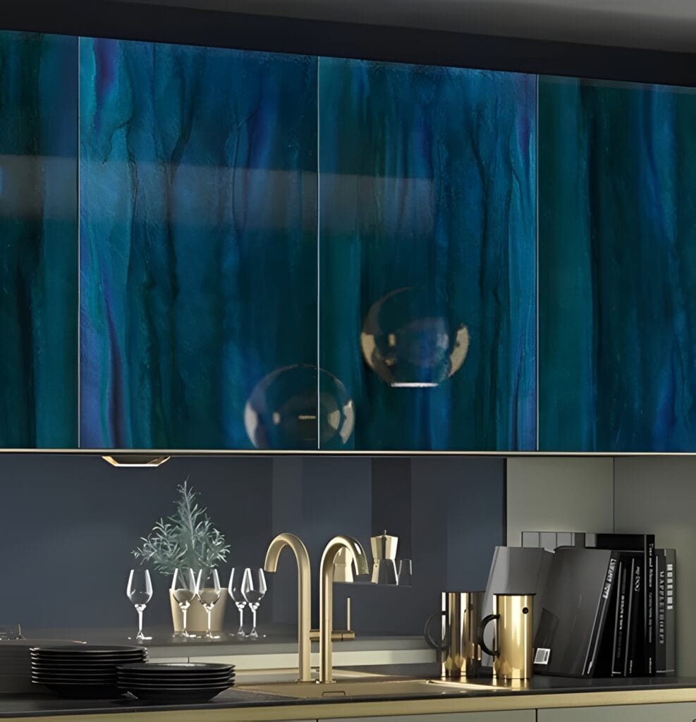 A modern kitchen with sleek, high gloss teal cabinets, a gold faucet, wine glasses, and decor items on the counter. A modern kitchen with blue-green marbled cabinetry, golden faucet, glasses, and black kitchen utensils arranged on the countertop; perfect for showcasing the immaculate results of deep cleaning for high gloss surfaces.