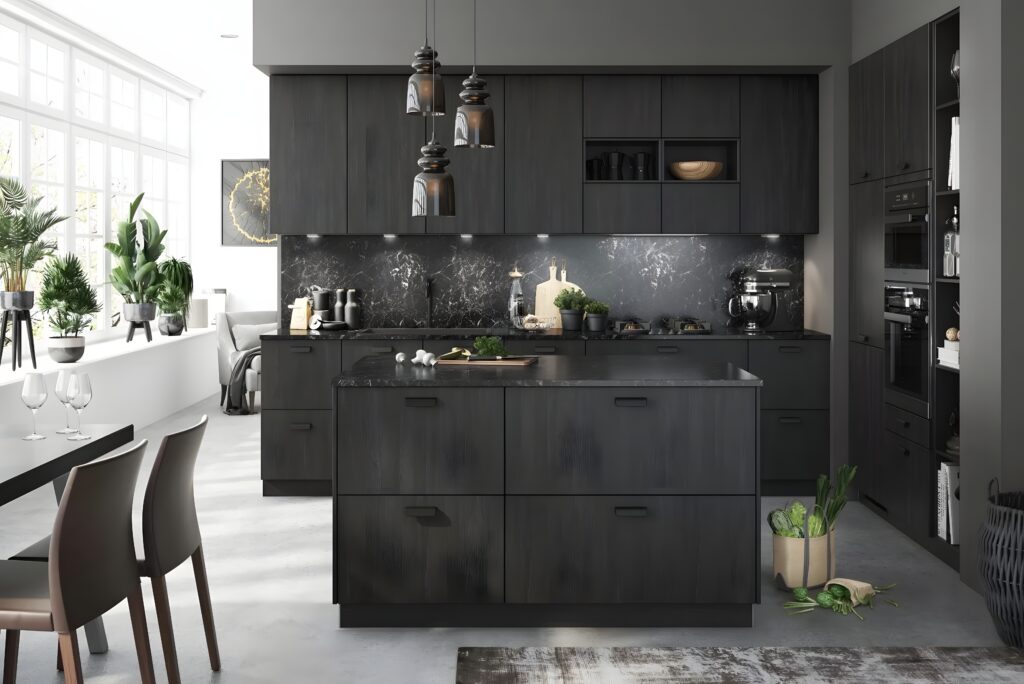 A modern kitchen with sleek black German kitchen cabinets and a marble backsplash. An island with drawers is in the center, and pendant lights hang above. Plants and kitchen items are displayed on the countertops and shelves, adding a touch of greenery to the sophisticated space.