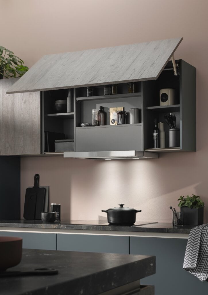 Modern kitchen with gray cabinets made from smart materials, open upper cupboards revealing kitchenware and spices, a black pot on the stove, and small plants on the countertop.