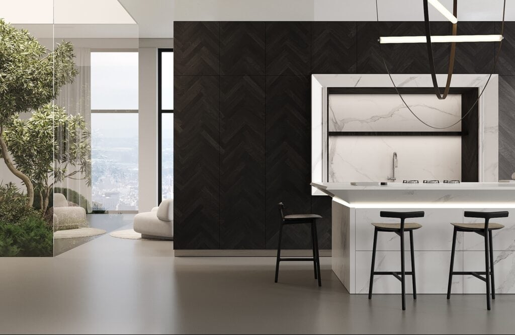 Modern kitchen with a marble island, black stools, and a geometric light fixture. Dark herringbone-patterned wall and adjacent indoor garden area are visible. Large window with city view in the background. The kitchen features touch-activated cabinet doors for a sleek and seamless look.