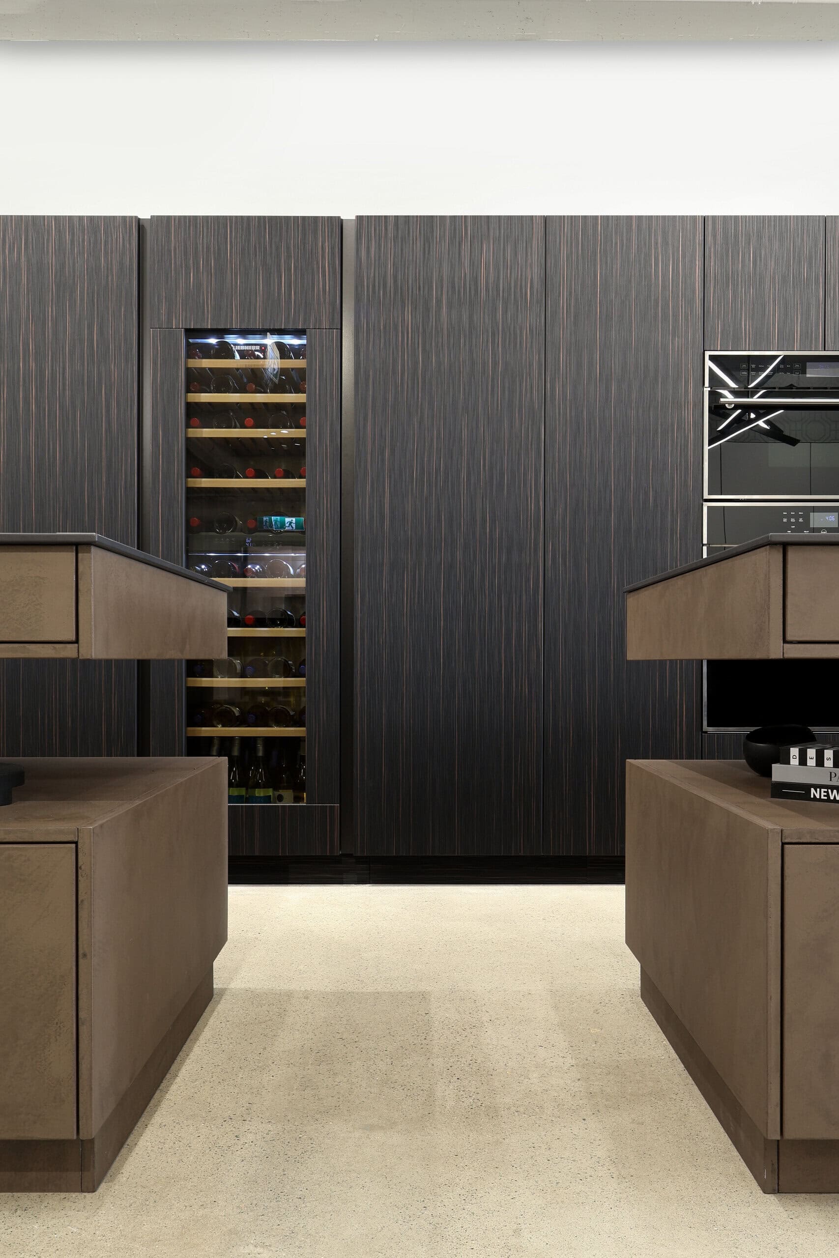 Bauformat kitchen display — ebony fronts, integrated wine wall