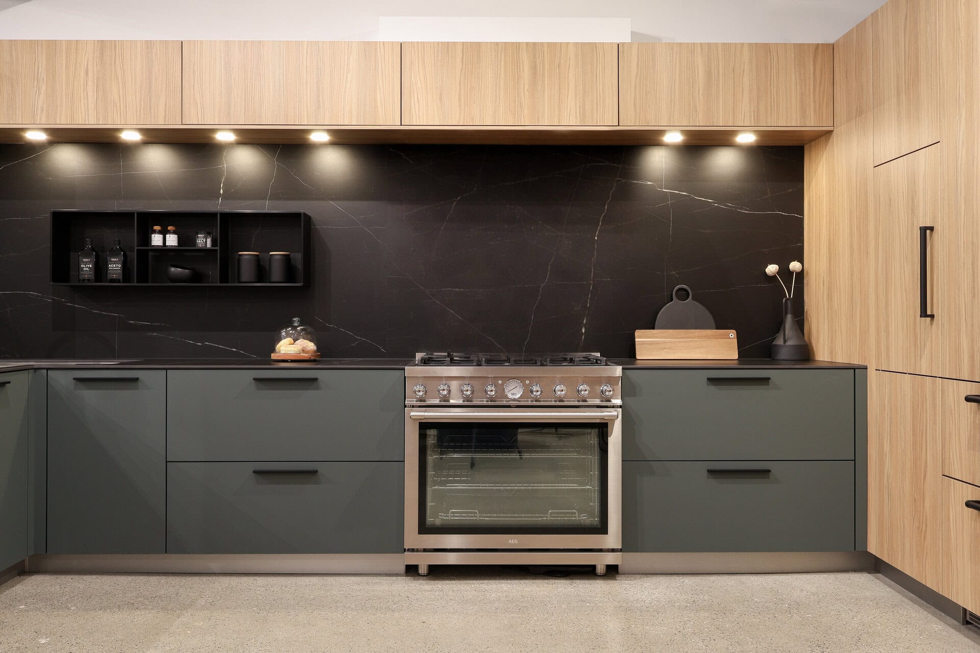 Bauformat kitchen display — matt lacquer range wall, oak tower