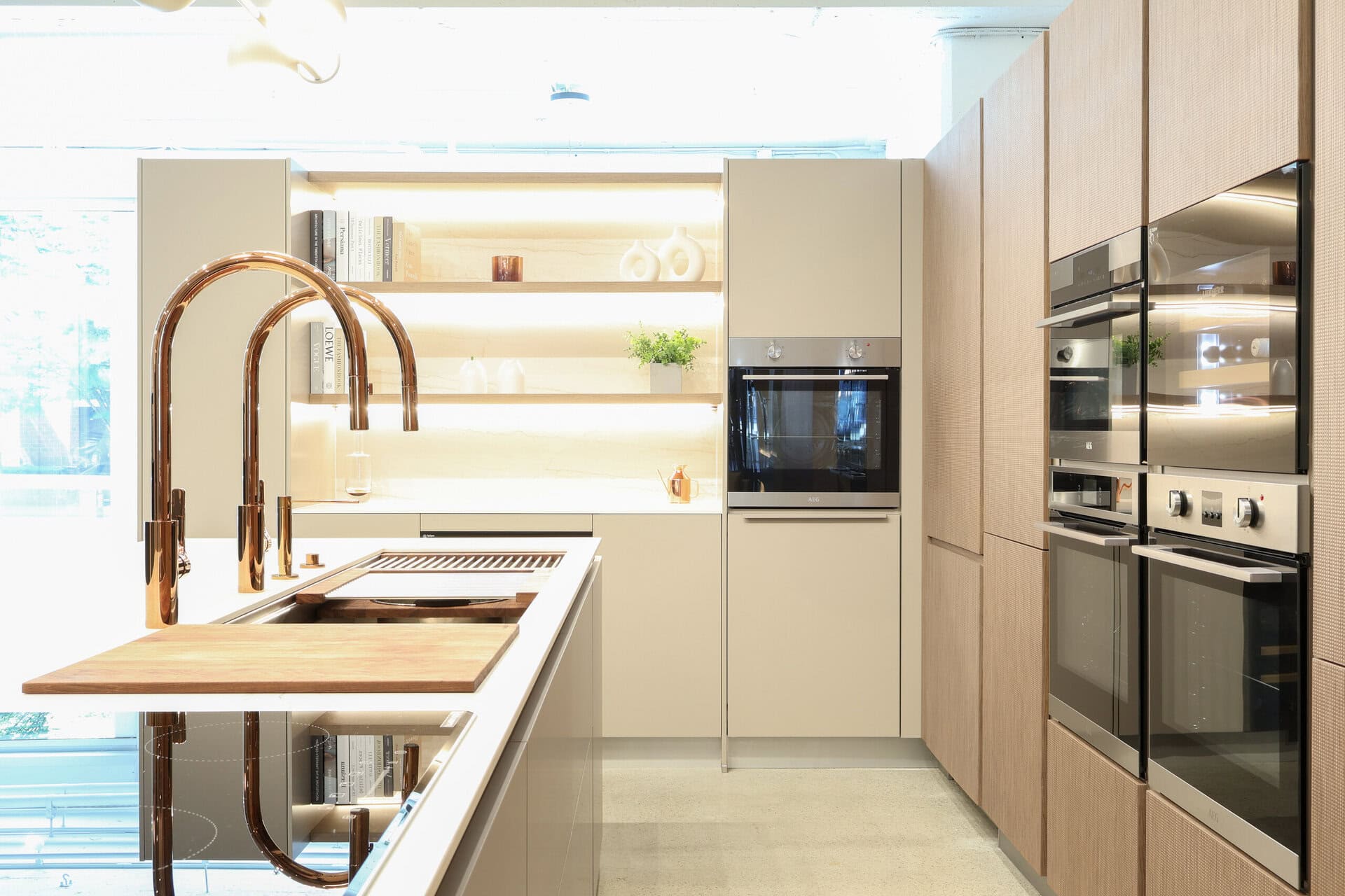Bauformat kitchen display — rose gold tap over textured walnut